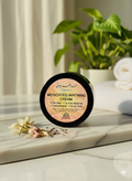 Jar of medicated whitening cream on a marble surface with plants in the background